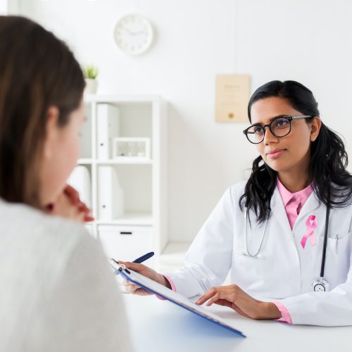 doctor with pink awareness ribbon and patient