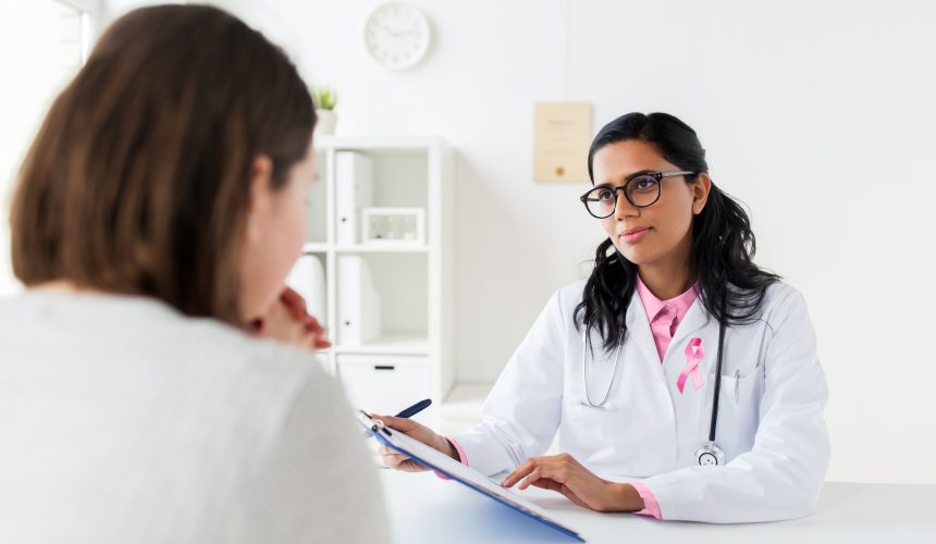 doctor with pink awareness ribbon and patient doctor with pink awareness ribbon and patient