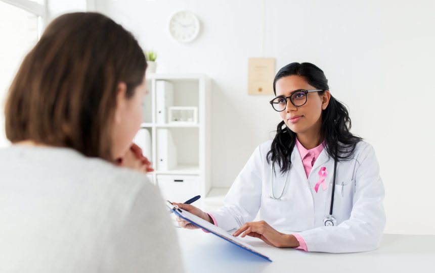 doctor with pink awareness ribbon and patient