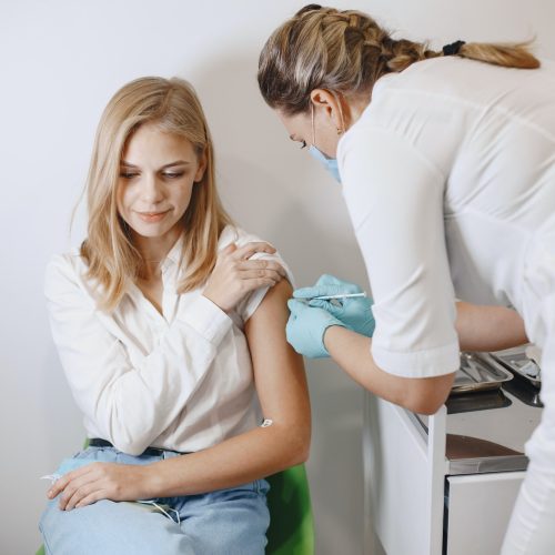 Woman doctor gives a vaccine to patients